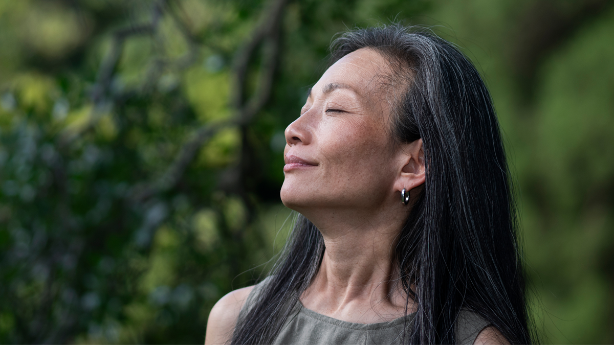 Woman with green bush behind