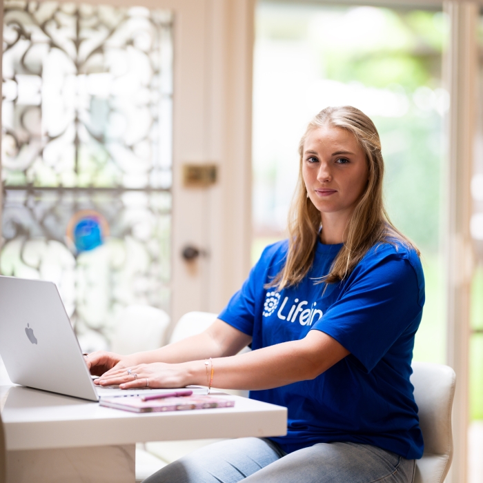 Lea, a Lifeline volunteer, on her laptop, ready to help