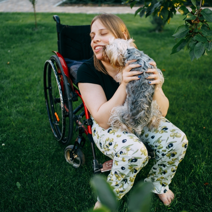 Living with a disability – Wheelchair user with their dog in the garden